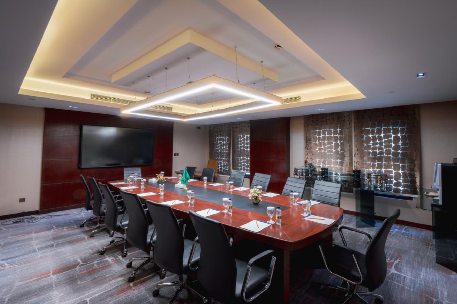 An executive boardroom with a single long polished table