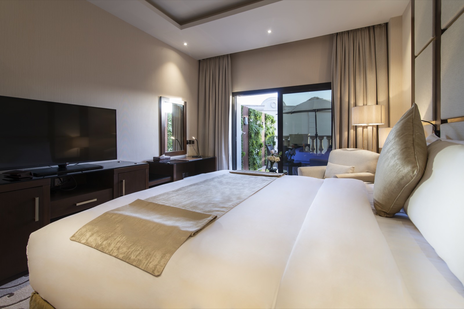 Family Suite bedroom with an armchair and marble bathroom beyond