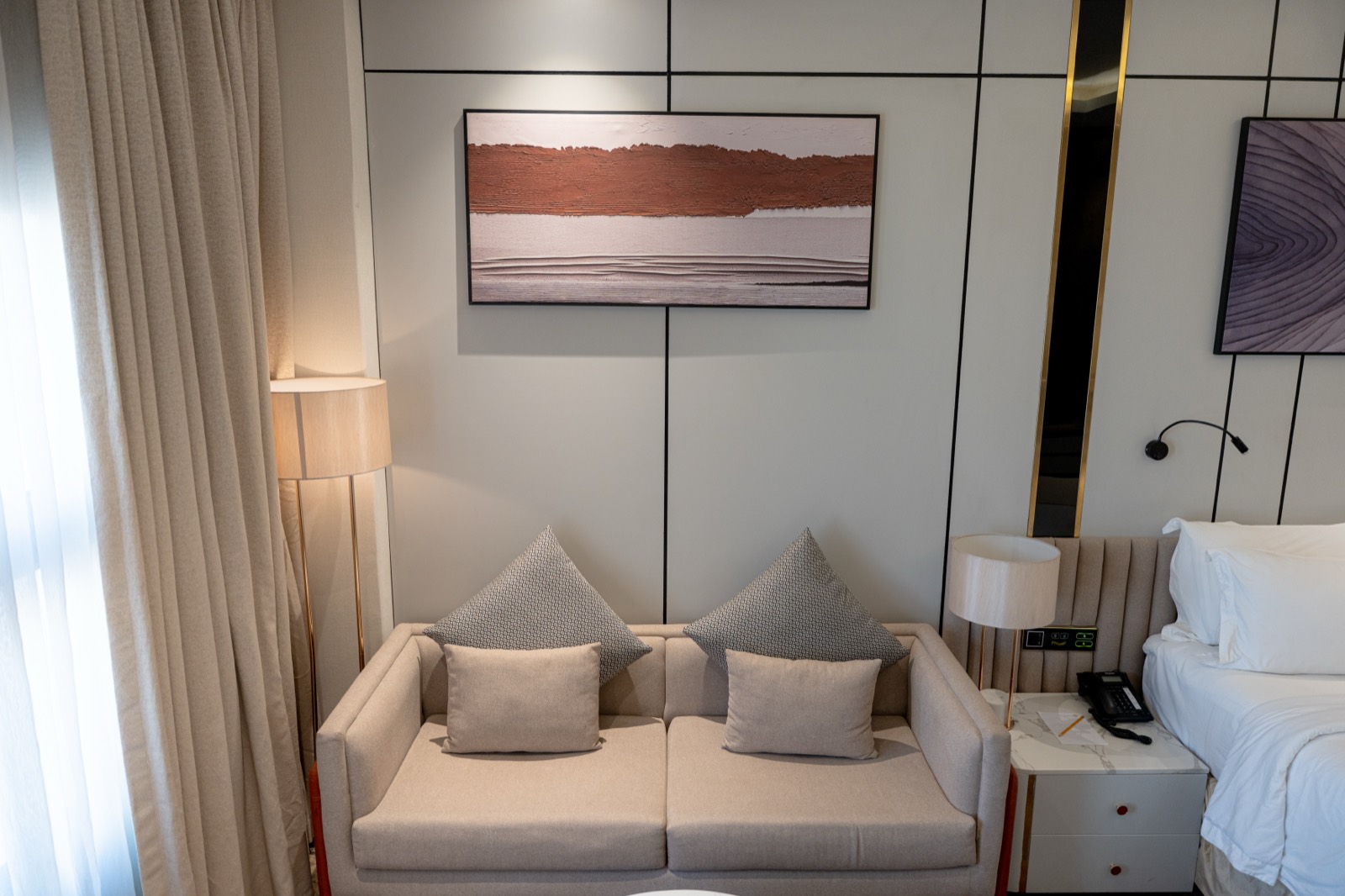 The Premium Room's sofa and bed beneath framed artwork