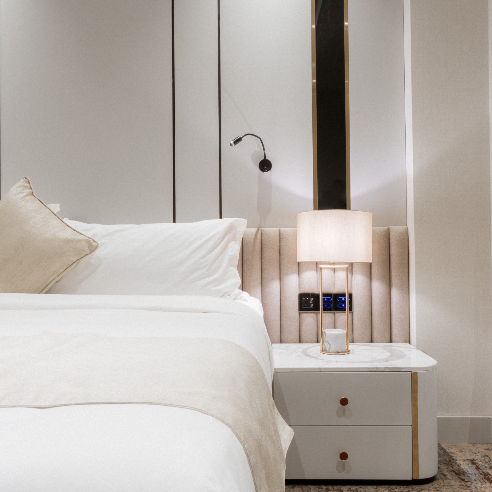 Bedside detail — the reading light and nightstand